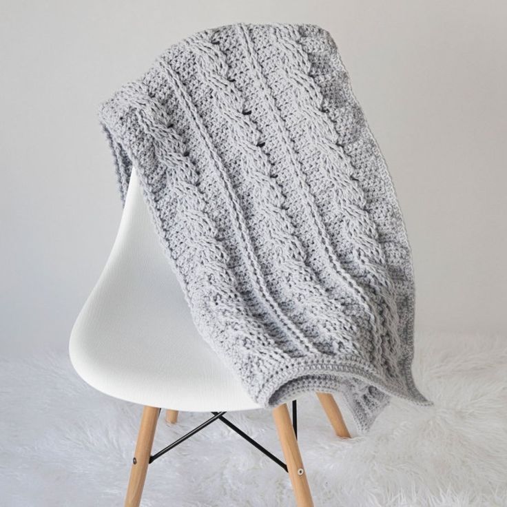 This is a fun project for anyone who loves the look of cables. The resulting blanket is not only beautiful to look at, but also super snuggly and warm. Materials: Size K-10.5 (6.5 mm) Crochet Hook. 14 Skeins Paintbox Yarns Simply Chunky Yarn in Misty Grey. Scissors. Measurements: Finished blanket measures: 33″ Wide X 59″ Long. Skill Level: Intermediate. Crochet Blanket Chunky, Crochet Cable Blanket, Beginner Crochet Blanket, Funky Crochet, Crochet Blanket Border, Cables Blanket, Striped Crochet Blanket, Throw Pillow Pattern, Throw Blanket Pattern