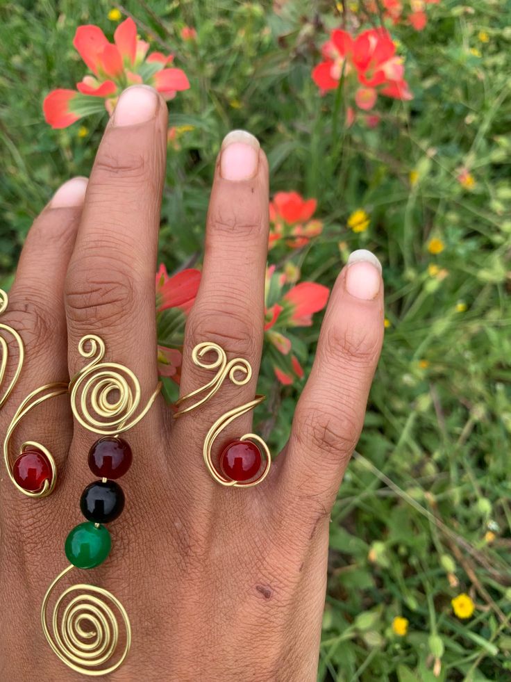 Gold wire adjustable Curl ring with Red Crystal. (Ring pictured on Ring finger) Hand Wrapped Round Red Jewelry, Hand Wrapped Red Round Jewelry, Red Hand Wrapped Round Jewelry, Adjustable Hand Wrapped Midi Rings, Unique Red Metal Rings, Unique Red Open Ring Jewelry, Red Wire Wrapped Metal Jewelry, Adjustable Open Ring In Red, Adjustable Wire Wrapped Red Jewelry