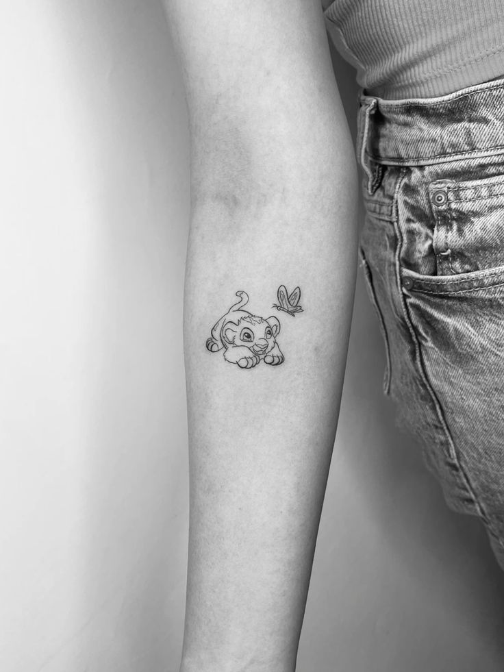 a woman's arm with a small elephant tattoo on the left side of her arm