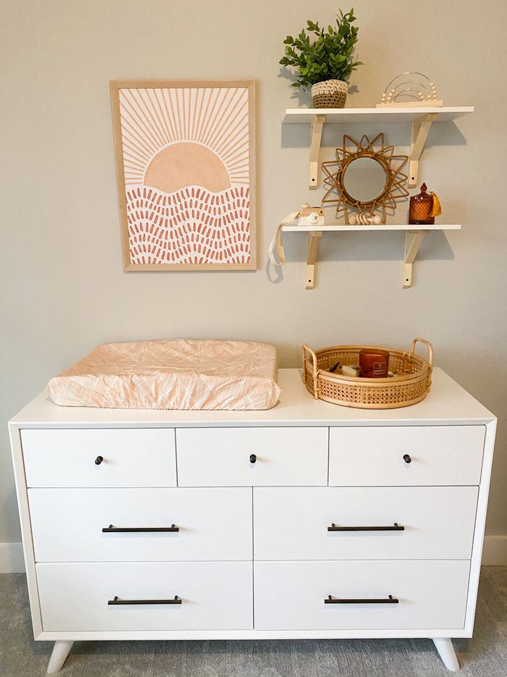 a white dresser with two shelves and a baby's crib