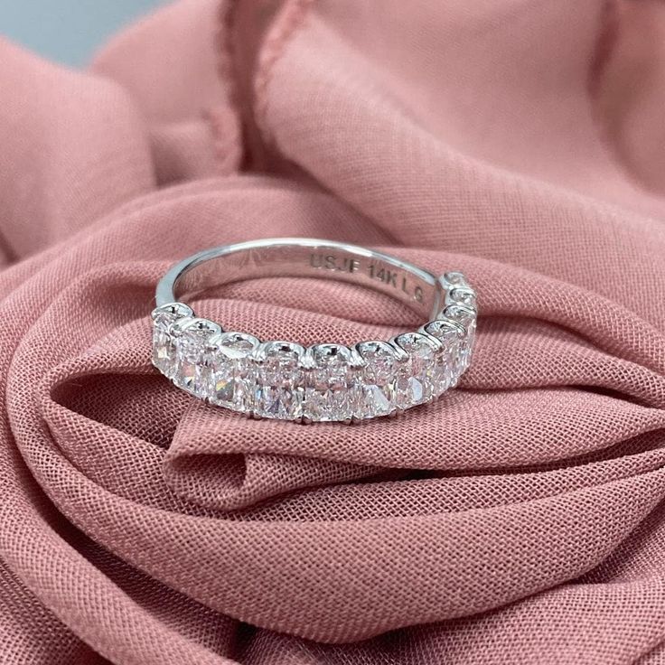 a diamond ring sitting on top of a pink cloth