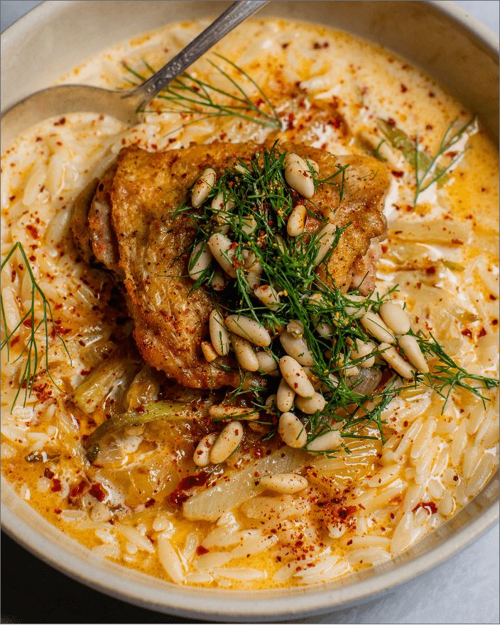 a close up of food in a bowl on a table with a spoon and fork