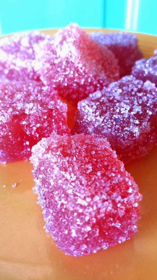 some pink sugar cubes on a yellow plate