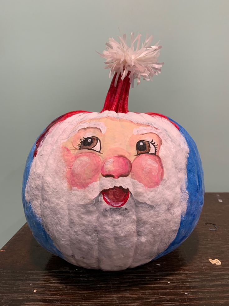 a painted pumpkin sitting on top of a wooden table