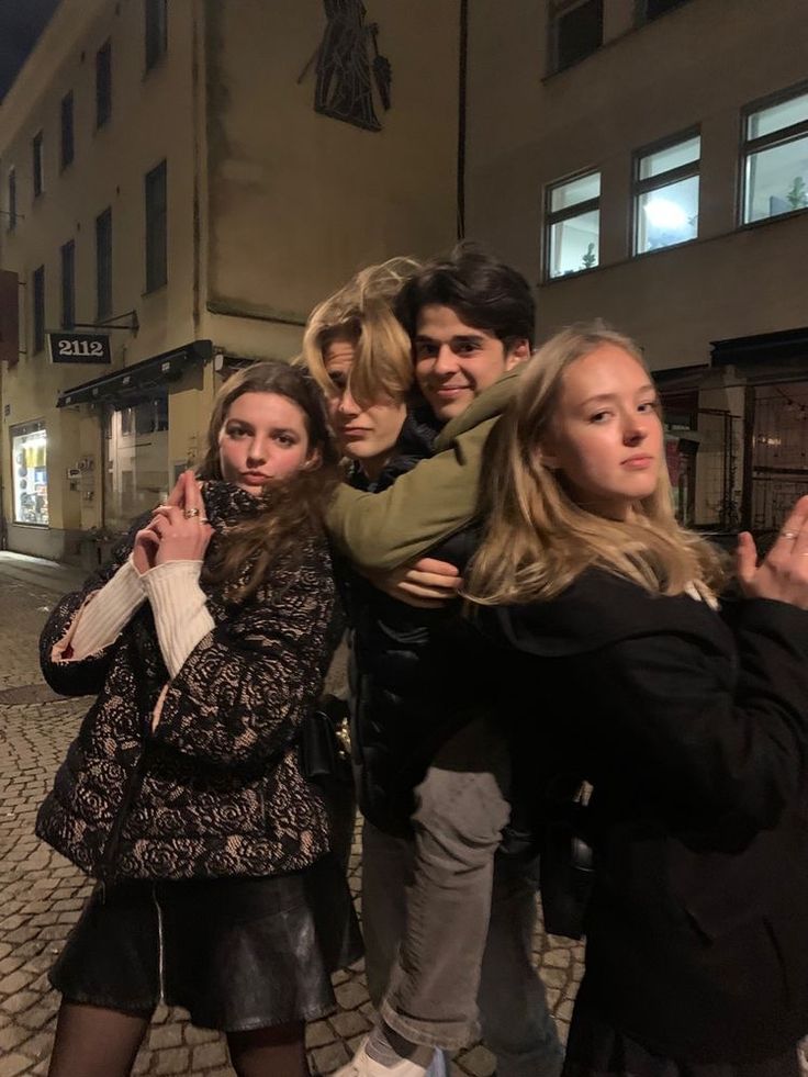 a group of people standing around each other in the street with their arms around one another