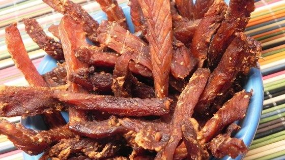 a blue bowl filled with bacon on top of a table