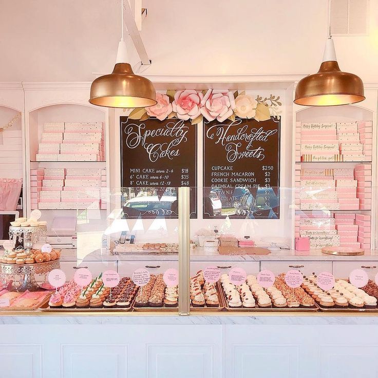 a bakery with pink and gold decorations on the counter