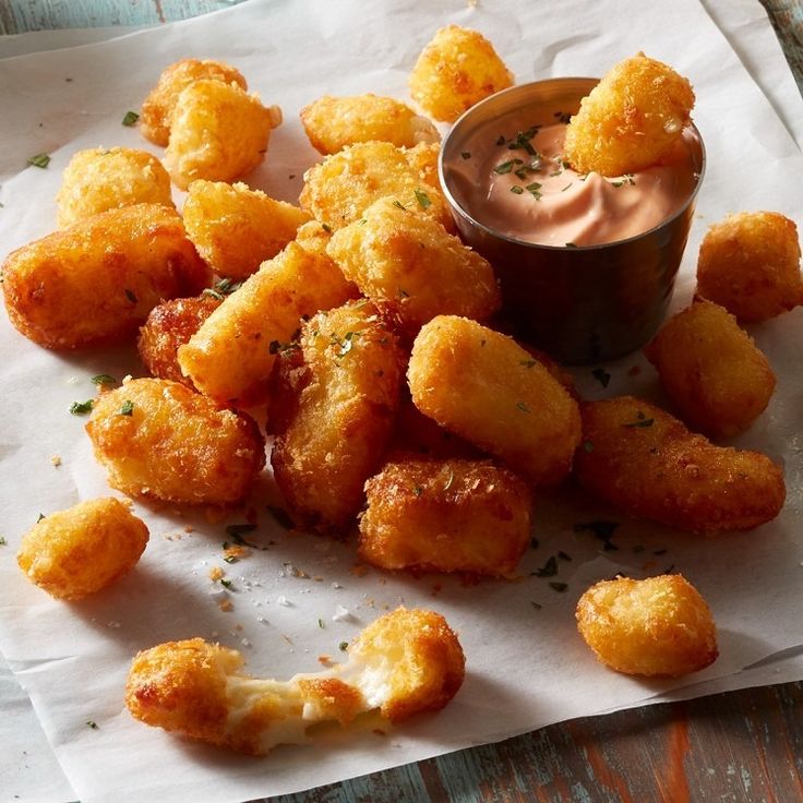 some fried food is sitting on a napkin with a dipping sauce in the middle and it's ready to be eaten