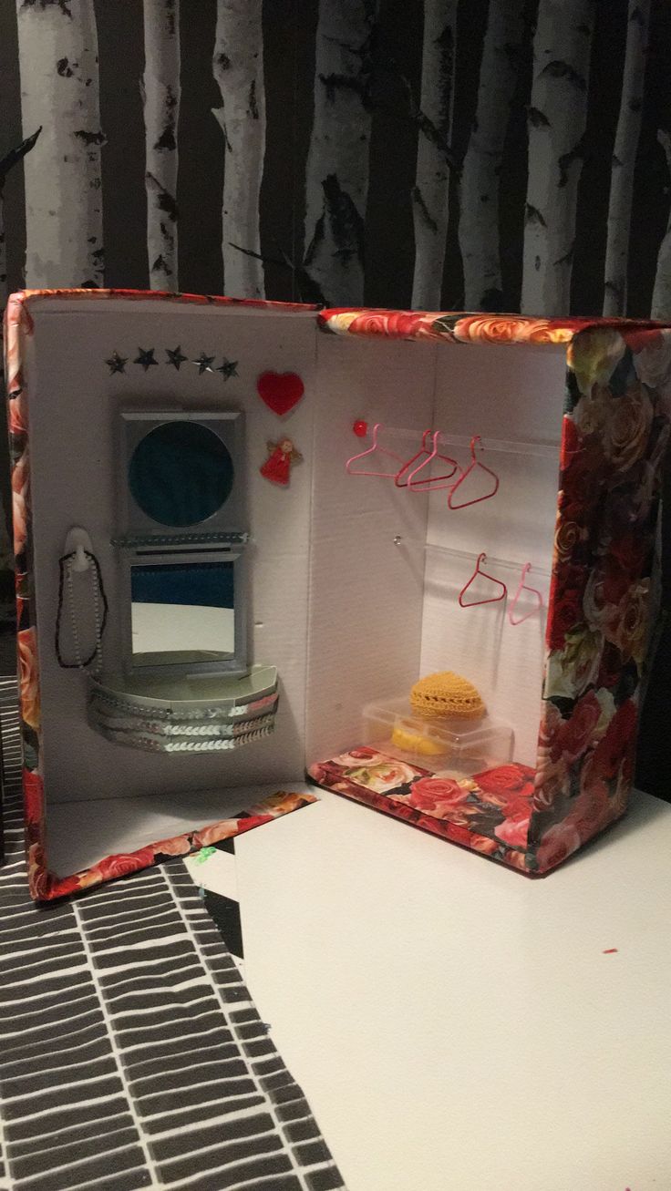 an open box on top of a table next to a wallpapered tree trunk