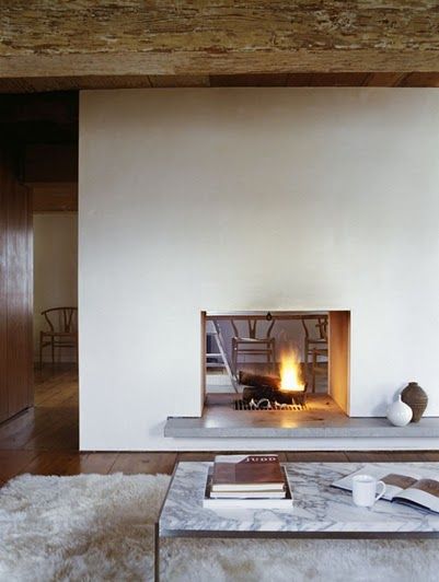 a living room filled with furniture and a fire place in the middle of it's wall