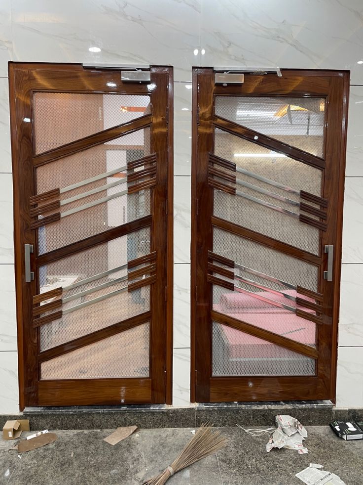 there are two doors that have been made out of wood and glass with blinds on them