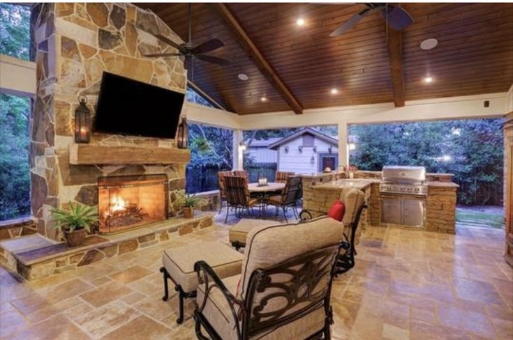 an outdoor living area with fireplace and television