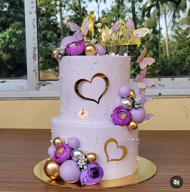 a three tiered cake with purple and gold decorations