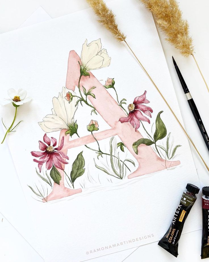 some flowers are sitting on top of a piece of paper next to watercolor pencils