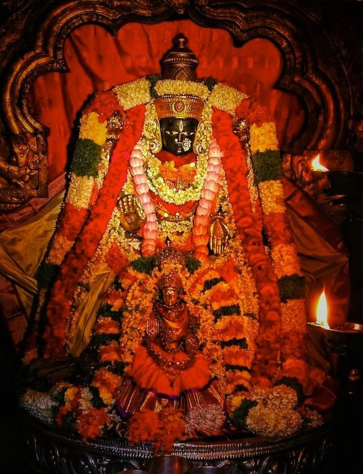 an idol is displayed in the middle of a stage with candles and flowers around it