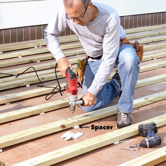 a man using a drill to cut wood planks