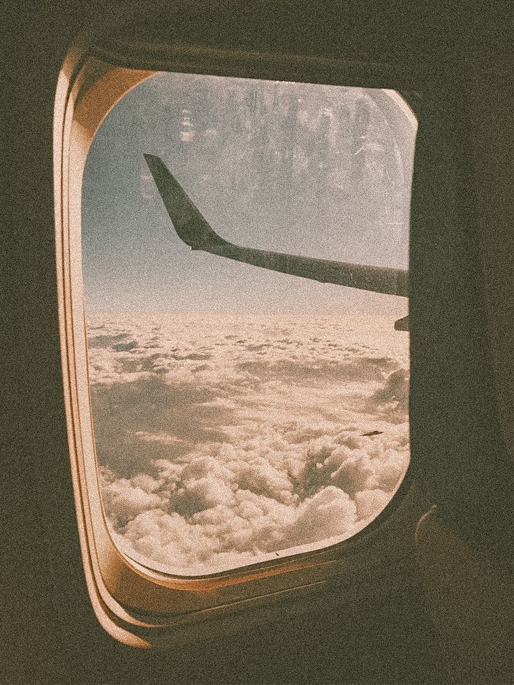 an airplane window looking out over the clouds