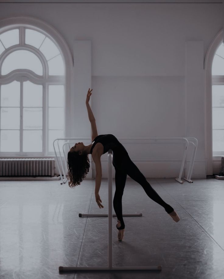 a woman is standing on a pole in an empty room