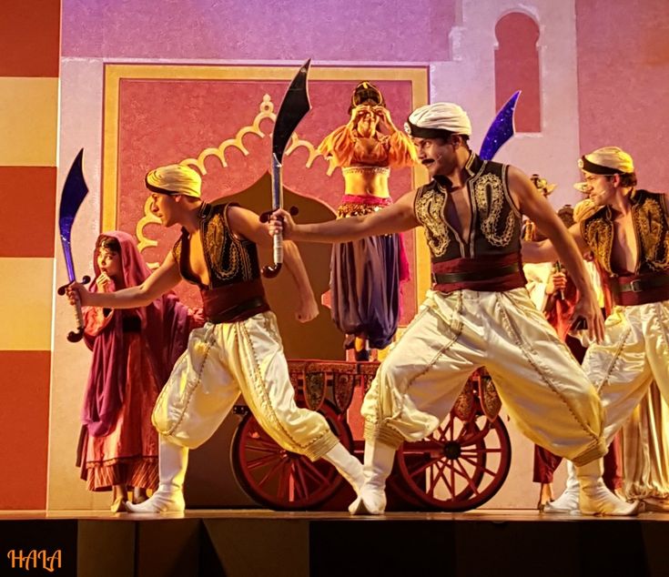 a group of people that are standing on a stage with some swords in their hands