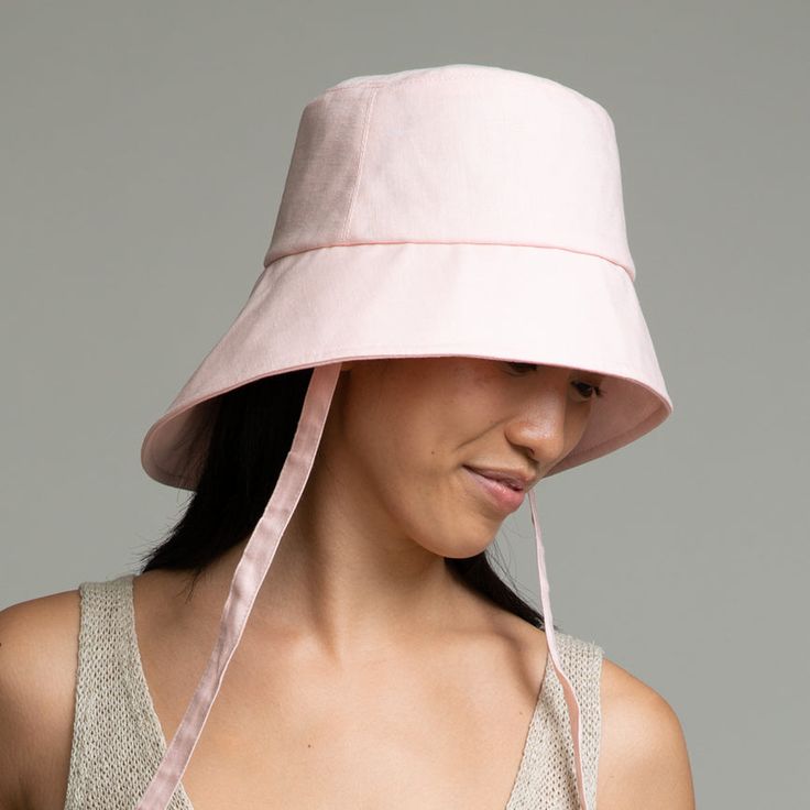 Pale pink linen asymmetric bucket hat with ties. SKU: 23508-03224 Pink Flat Brim Bucket Hat, Spring Pink Flat Brim Bucket Hat, Pink Flat Brim Bucket Hat For Spring, Pink Short Brim Bucket Hat For Summer, Pink Summer Bucket Hat With Short Brim, Pink Wide Brim Bucket Hat For Summer, Adjustable Pink Bucket Hat For Summer, Pink Wide Brim Bucket Hat, Adjustable Pre-tied Spring Hat