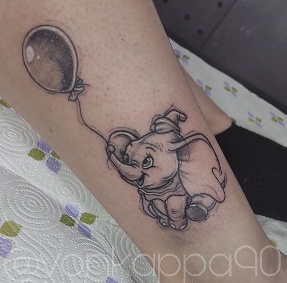 an elephant with a balloon tattoo on it's leg is seen in this image