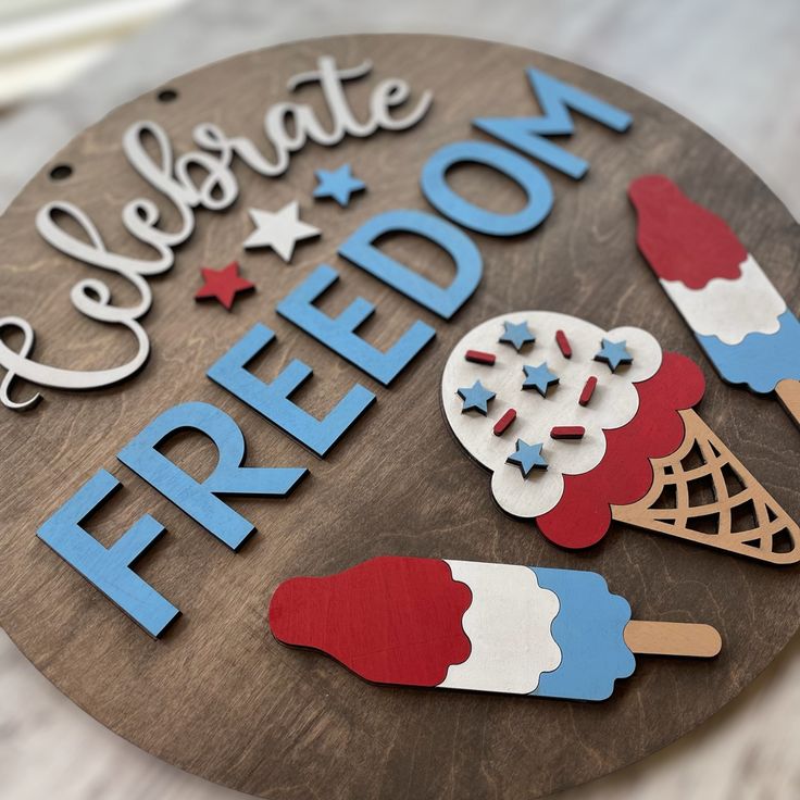 a wooden sign that says celebrate freedom with popsicles and ice cream on it's side