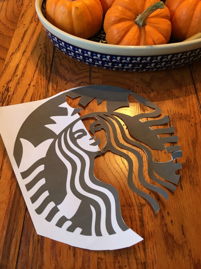 the starbucks logo is cut out and placed next to some pumpkins in a bowl