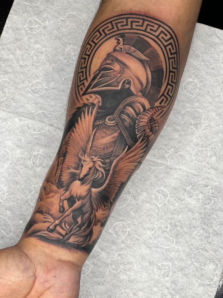 a man's arm with an egyptian tattoo on it and a bird in the middle