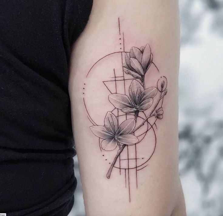 a woman's arm with flowers on it and a geometric design in the background