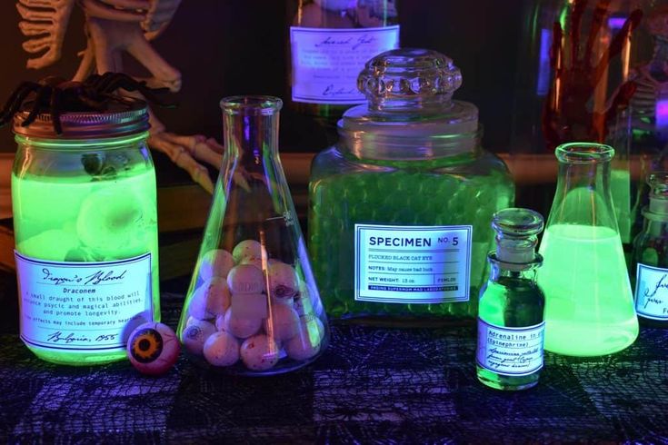 jars filled with different types of ingredients on a table top next to skeleton bones and other items