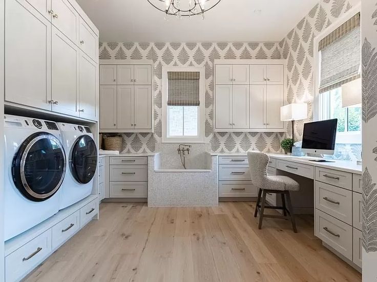 a washer and dryer are in the middle of a room with white cabinets