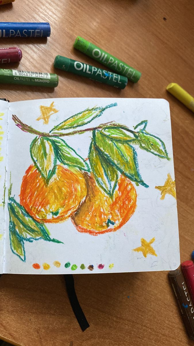 a child's drawing of two oranges with leaves and stars on the page