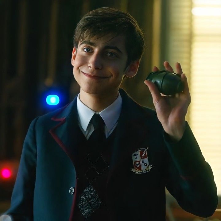 a young man in uniform holding up a green object