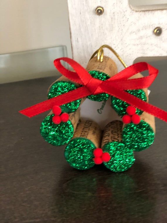 an ornament made out of wine corks with red ribbon