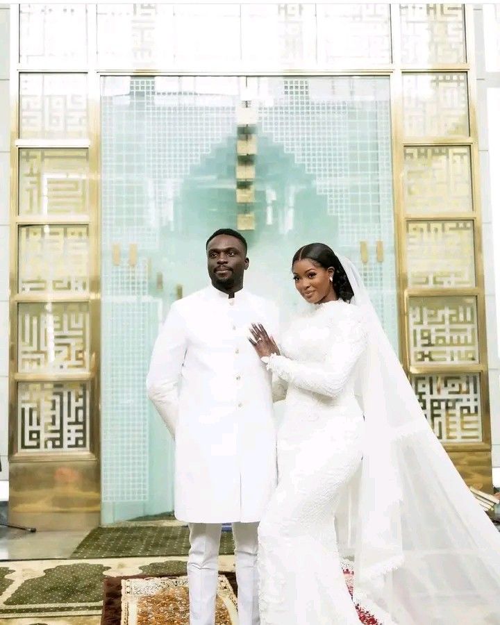 a man and woman dressed in white standing next to each other