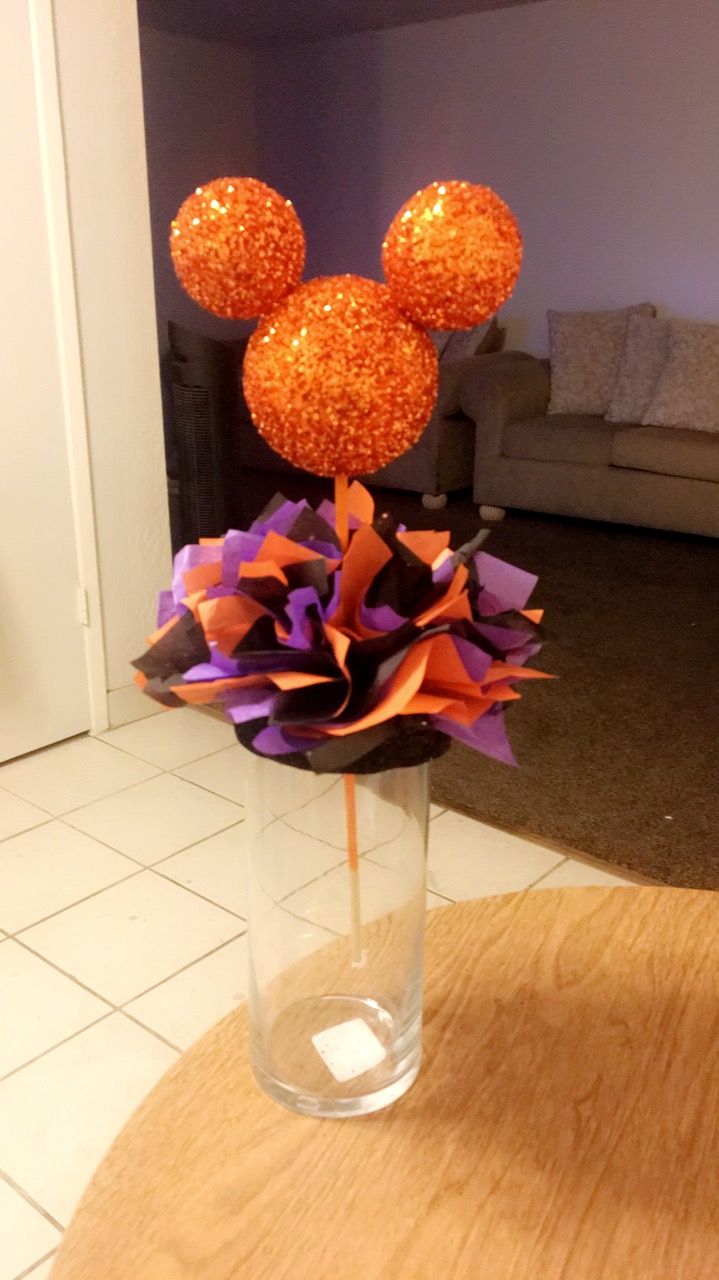 a glass vase with some orange and purple decorations in it on top of a table