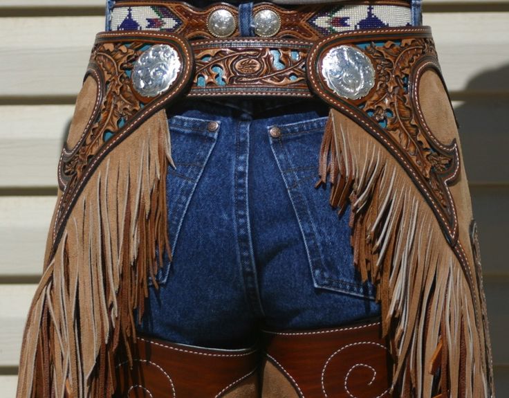 the back of a woman's cowboy boots with fringes and beads on them