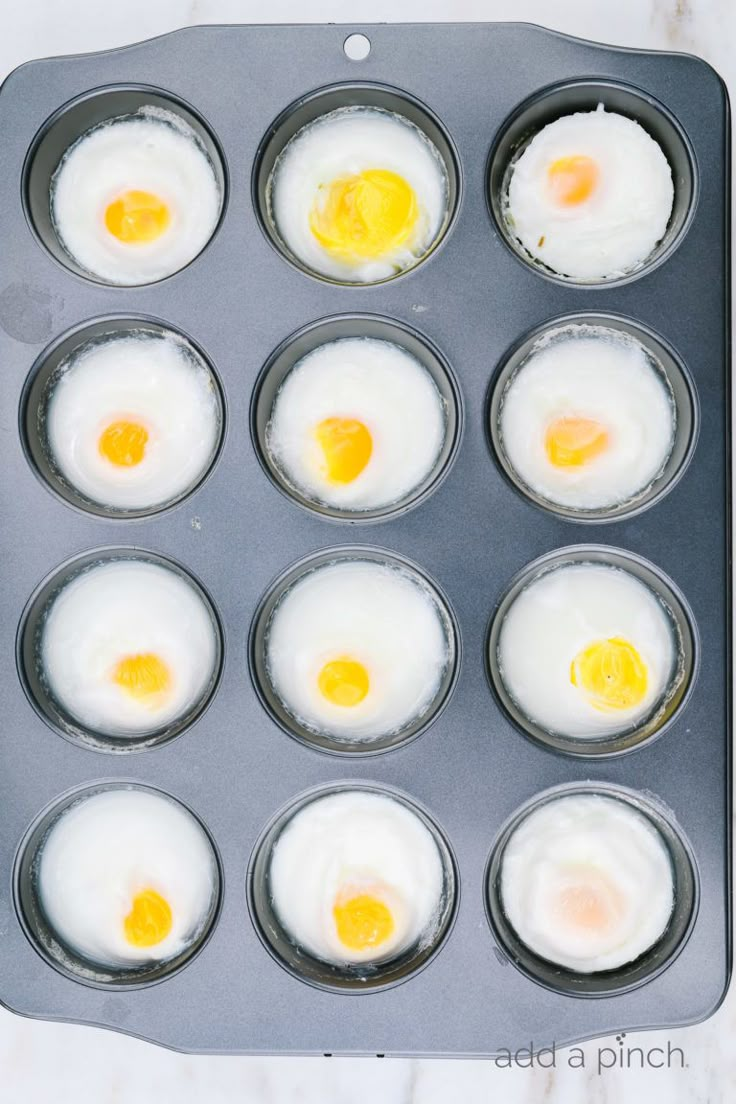 eggs in a muffin pan with yolks on top, ready to be cooked