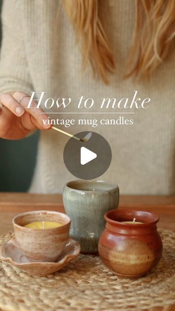 a woman holding a wooden spoon over two small cups with candles in them on top of a table