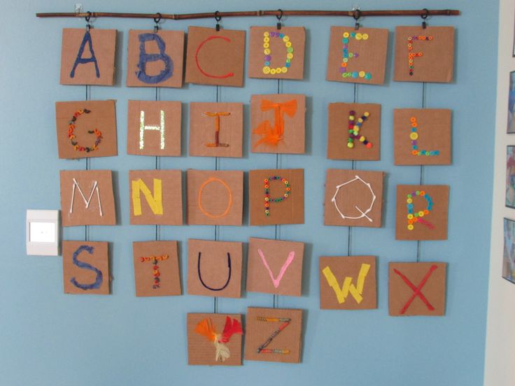 the letters are made out of brown paper and hung on a wall with pegs