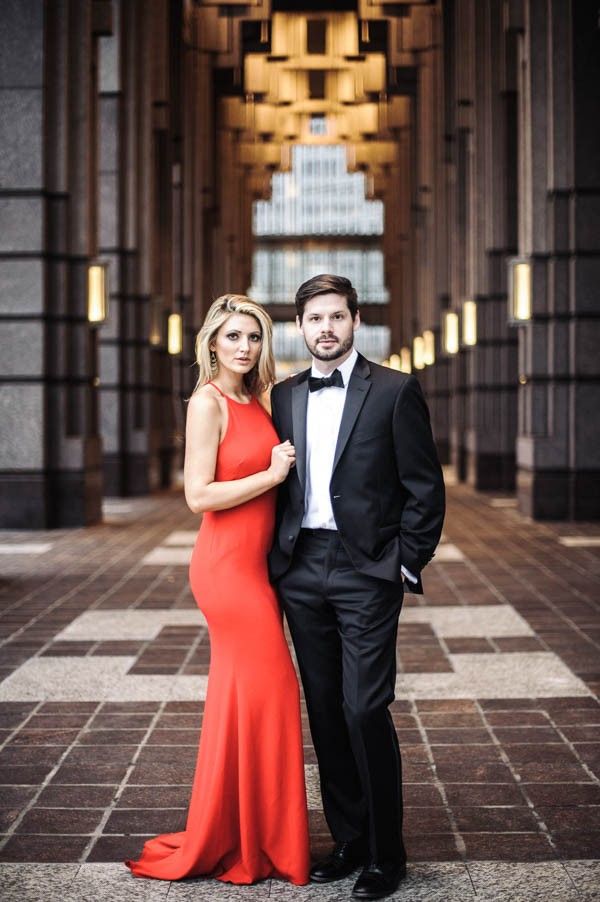 a man in a tuxedo and a woman in a red dress pose for a photo