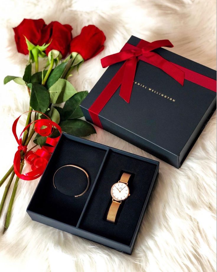 two roses and a watch in a gift box