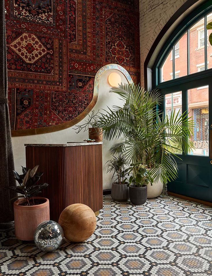 a room that has some plants and rugs on the floor