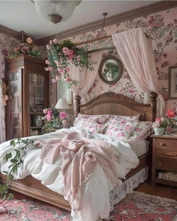 a bedroom with pink flowers on the walls and bed in front of a dresser, mirror and window