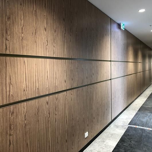 an empty hallway with wood paneling on the walls and carpeted floor, along with lights