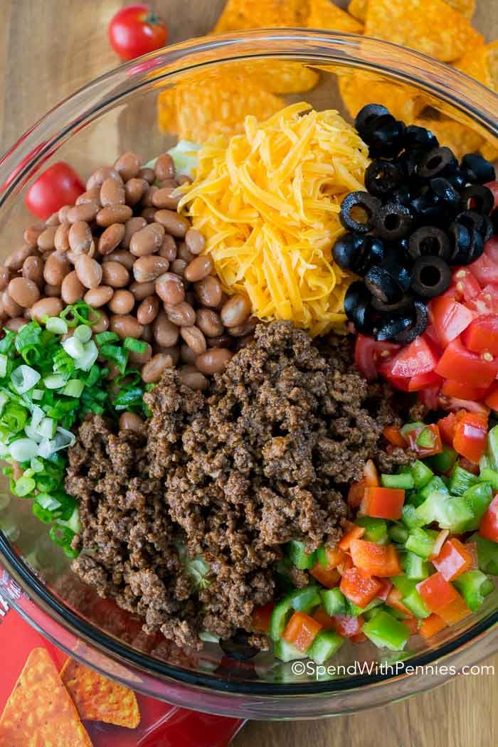 a glass bowl filled with taco salad ingredients