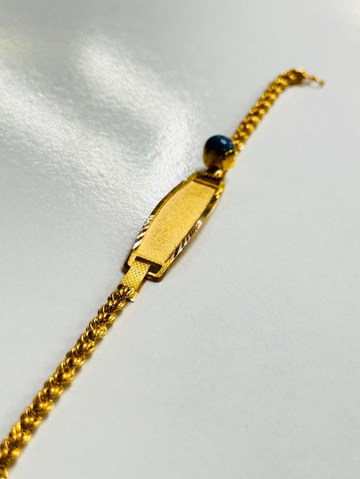 a gold chain with a blue bead on it