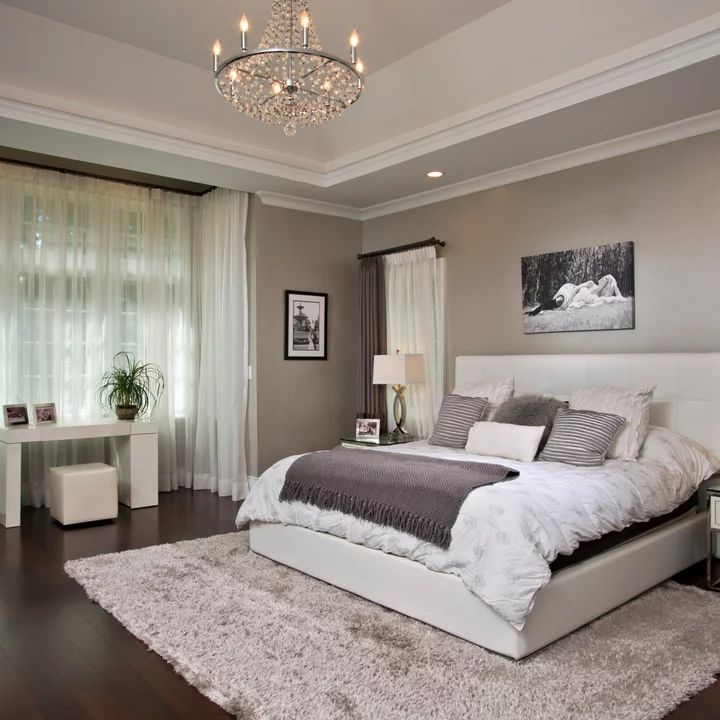 a bedroom with a large bed and chandelier