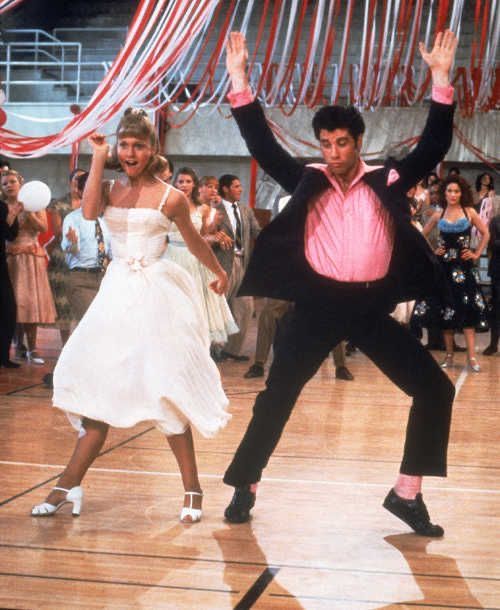 two people dancing on a dance floor with red and white streamers