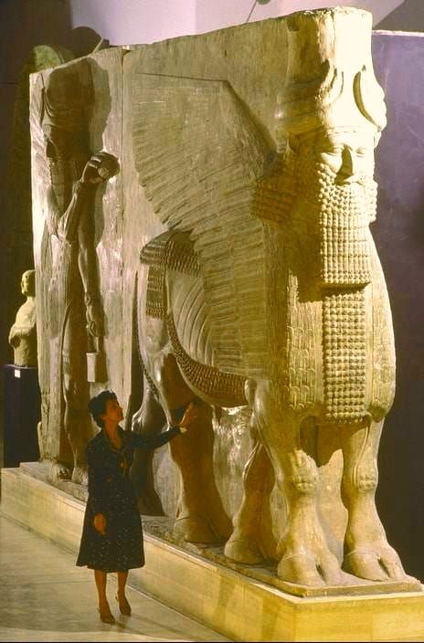 a woman standing in front of an elephant statue